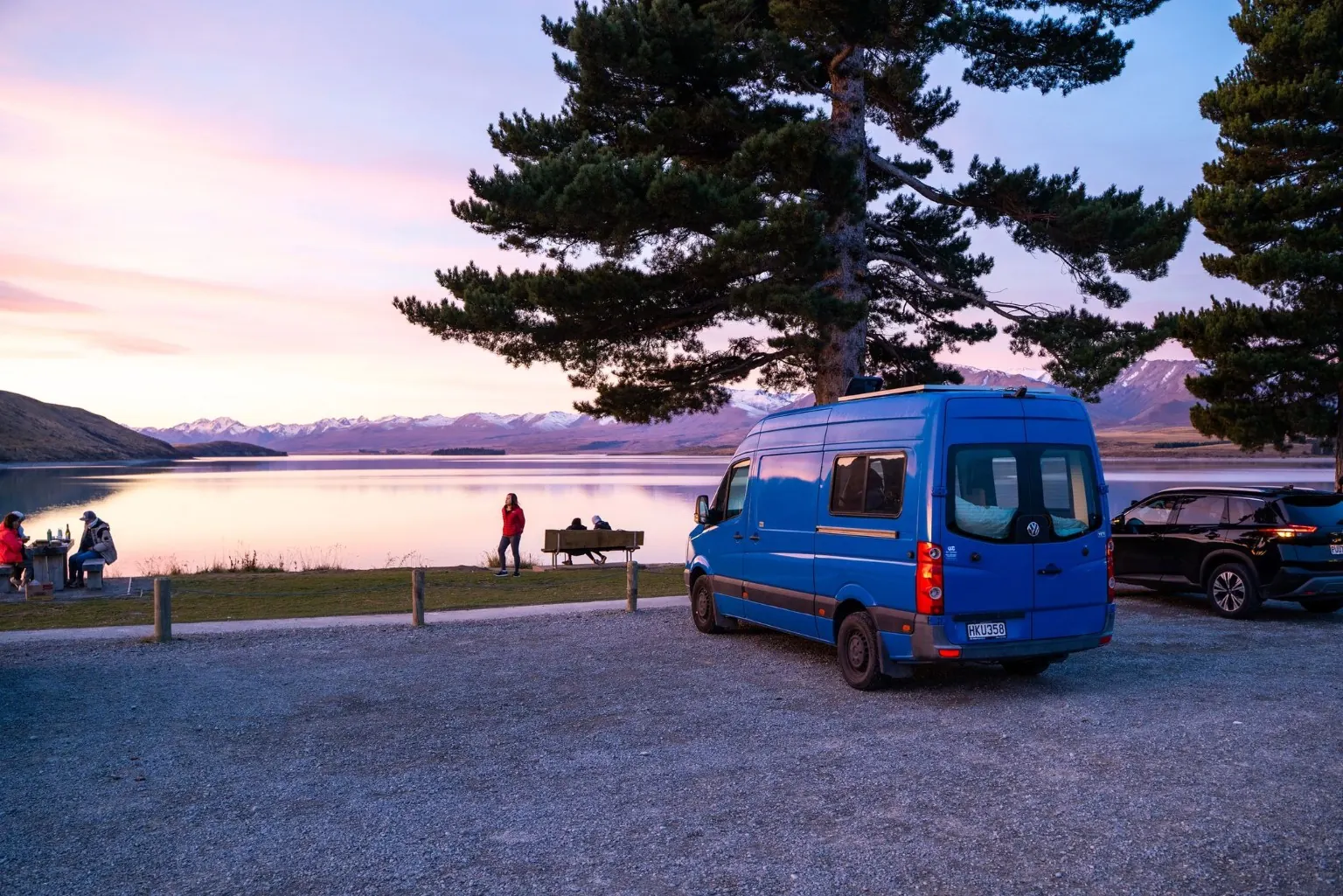 le van aménagé au bord d’un lac de l’île du Sud au coucher du soleil